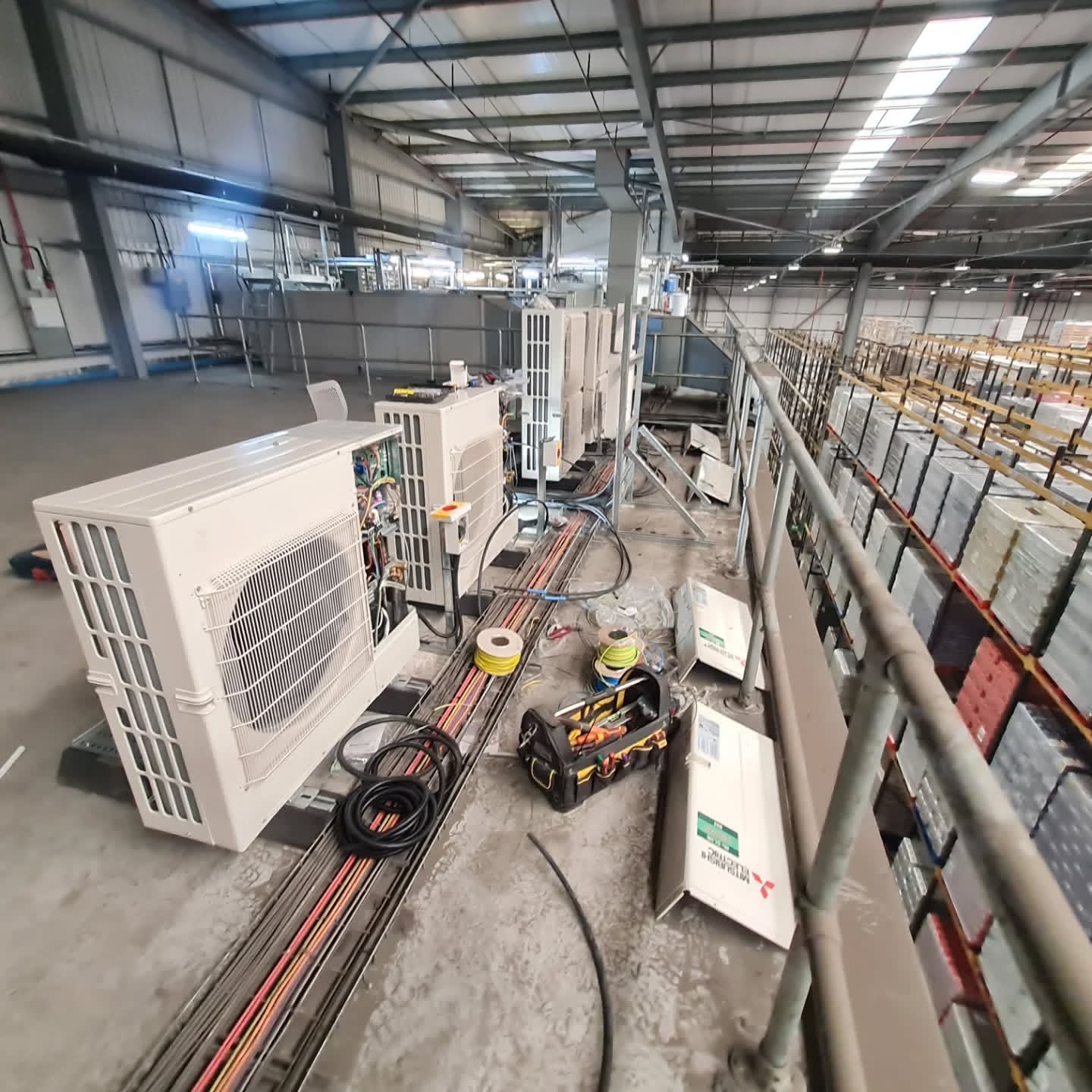 Air conditioning condenser units and cable containment installed in a distribution warehouse