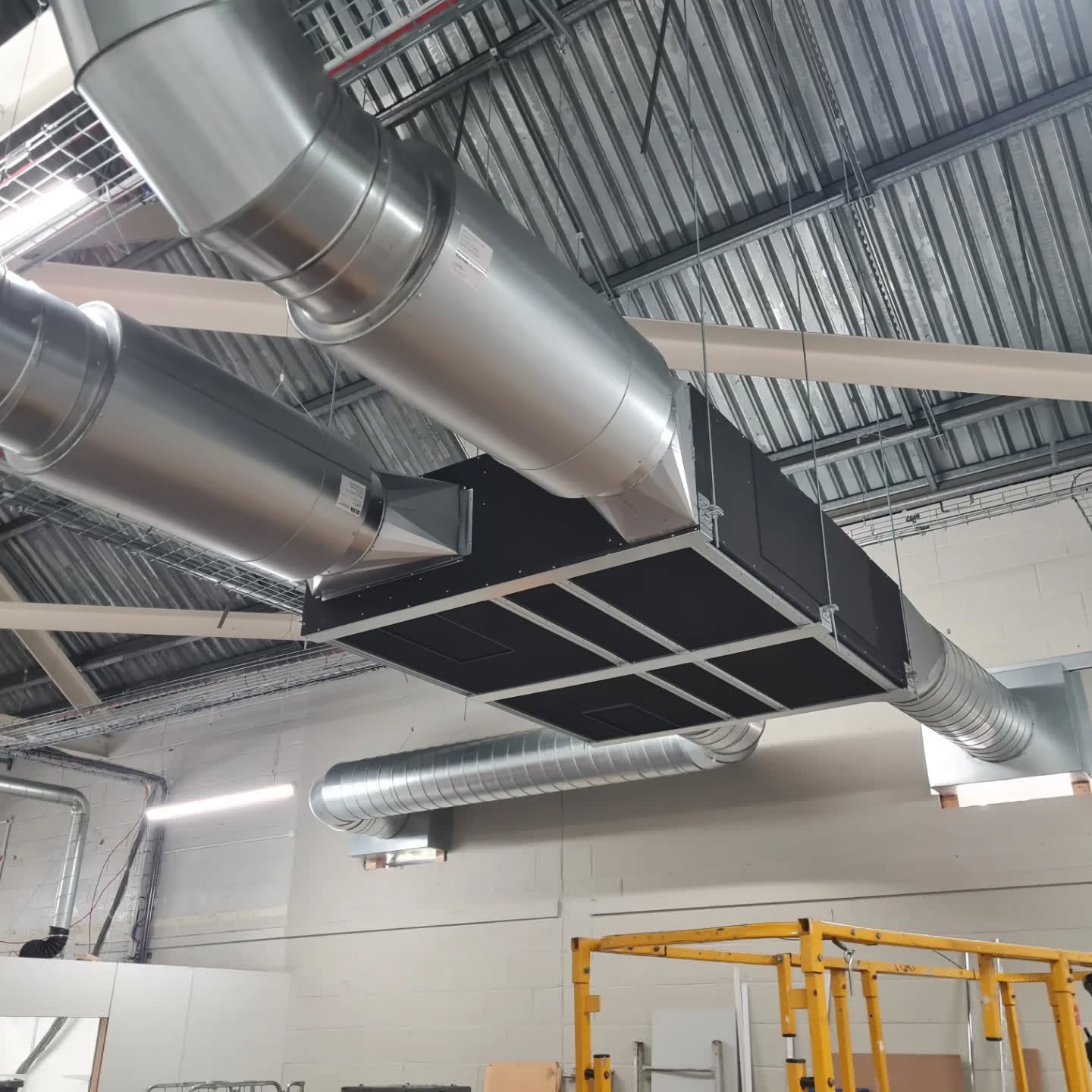 Ducted air handling unit and spiral ductwork installed at high level in a workshop